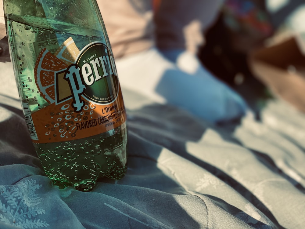 green plastic bottle on blue textile