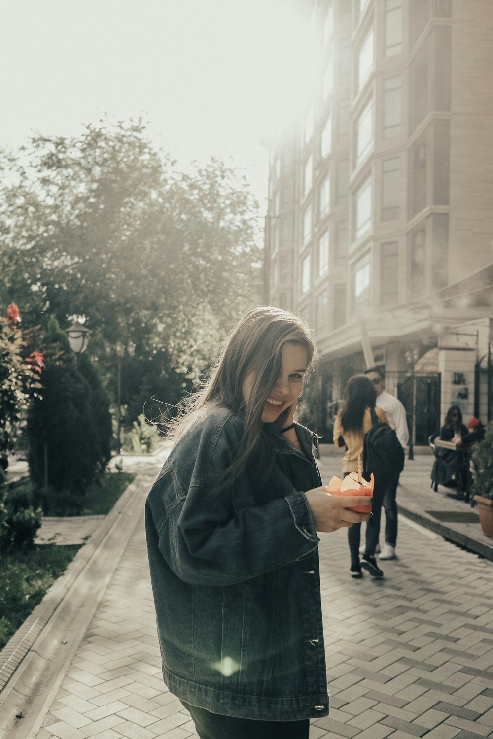 woman in black coat standing on sidewalk during daytime