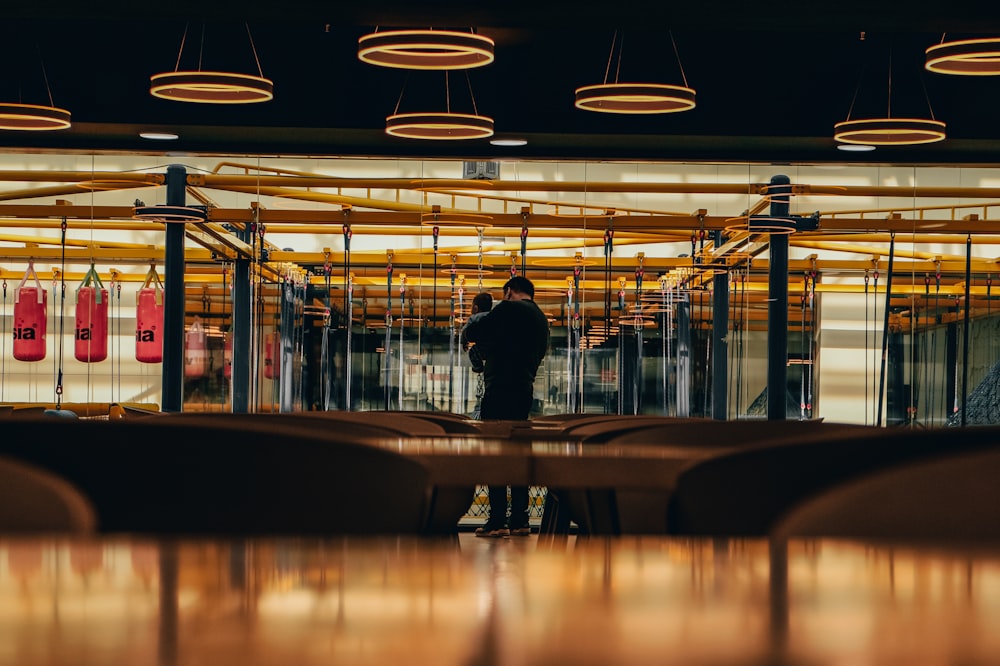 man in black jacket standing near glass window