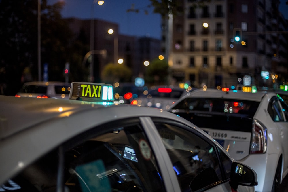 white and black taxi cab on road during night time