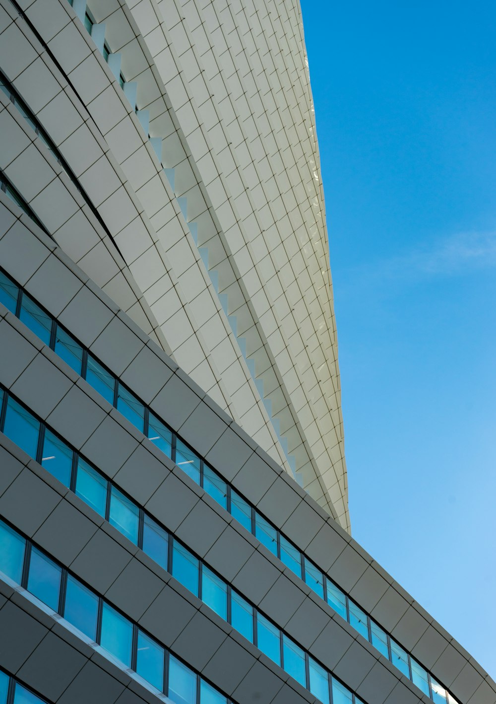 white and blue glass walled high rise building