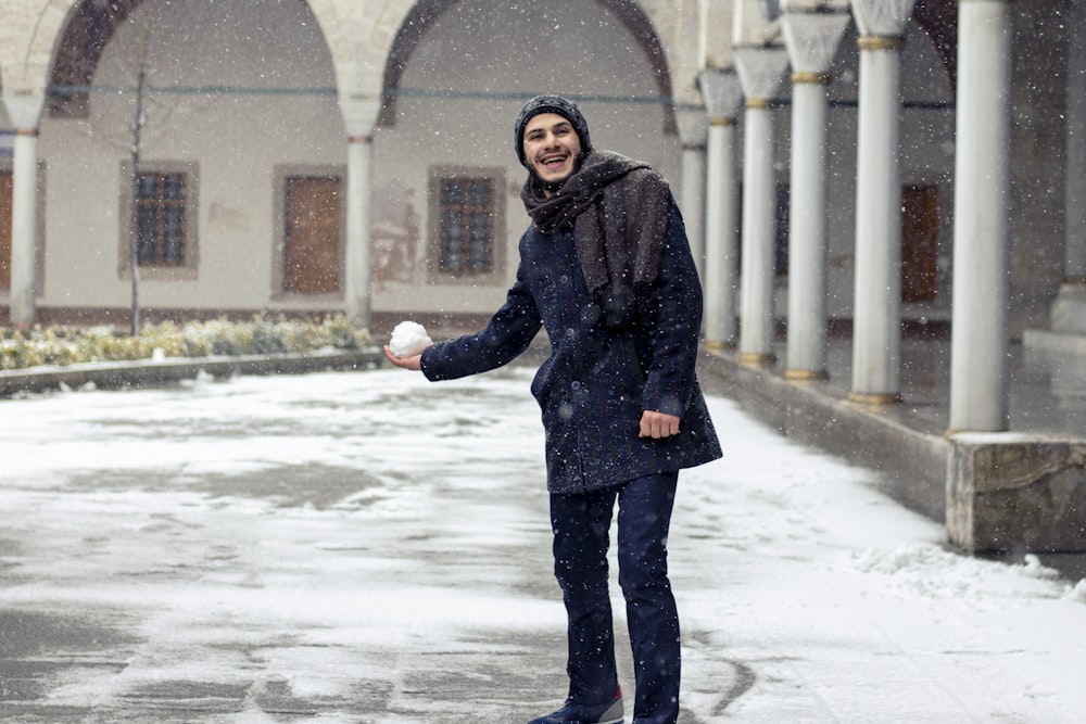 woman in black coat standing on snow covered ground during daytime