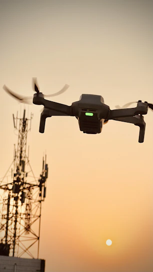 A drone capturing aerial photos over a modern office building at sunset.