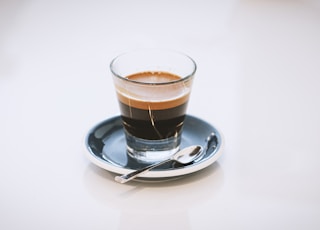 clear glass cup on saucer