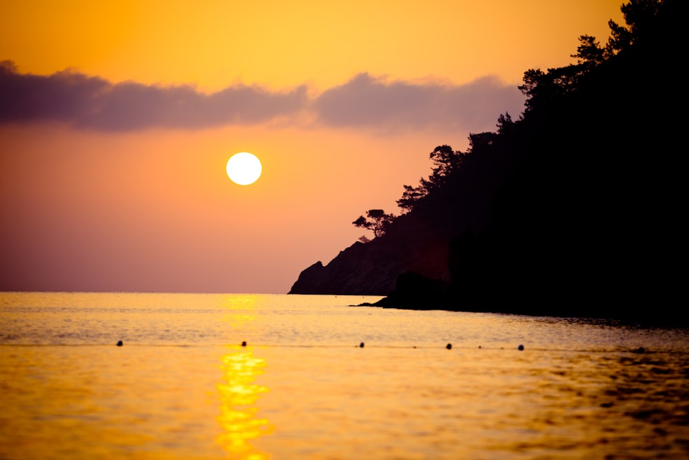 silhouette of mountain and trees during sunset