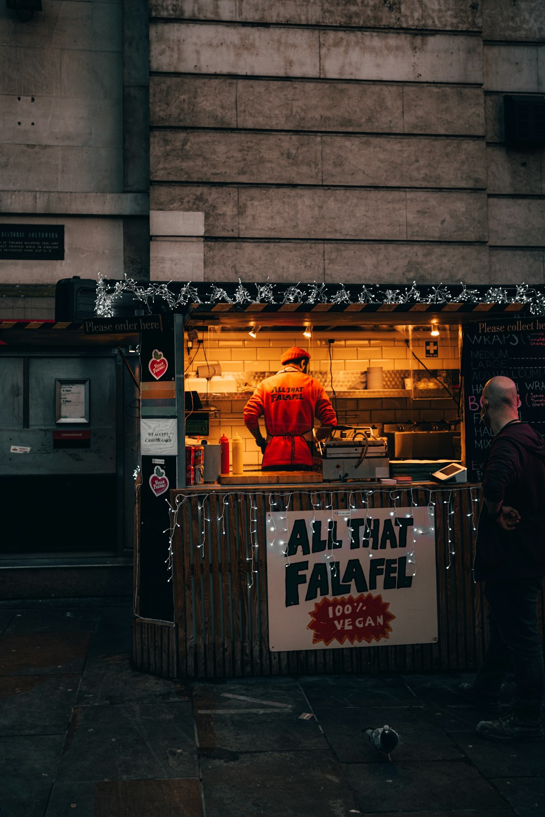 man in black jacket standing in front of store