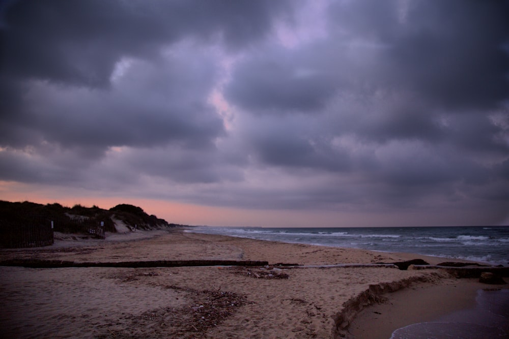 sea waves crashing on shore during sunset