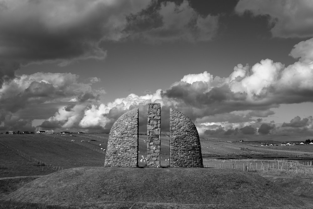 grayscale photo of dome building under cloudy sky