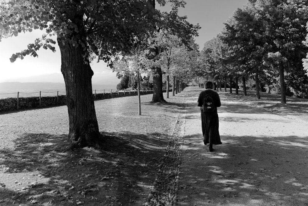 Persona con abrigo negro caminando por un camino cubierto de nieve