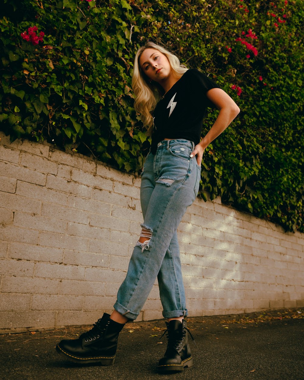 Woman in black t-shirt and blue denim jeans standing beside green plant  during daytime photo – Free Clothing Image on Unsplash