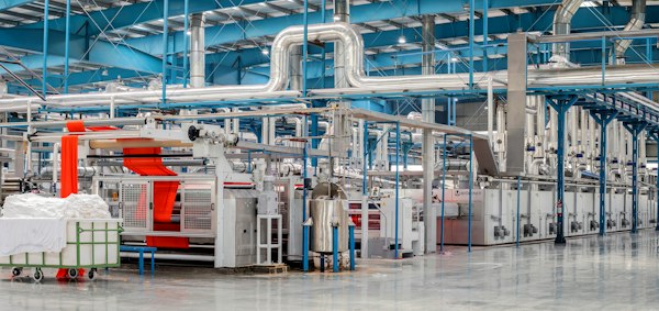 Planta de acabado textil con maquinaria y tuberías, terreno del marketing digital para industria textil