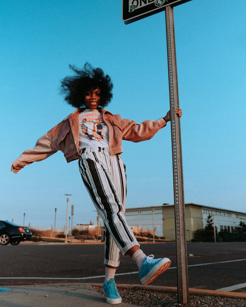 woman in white and red long sleeve shirt and white pants standing on street during daytime