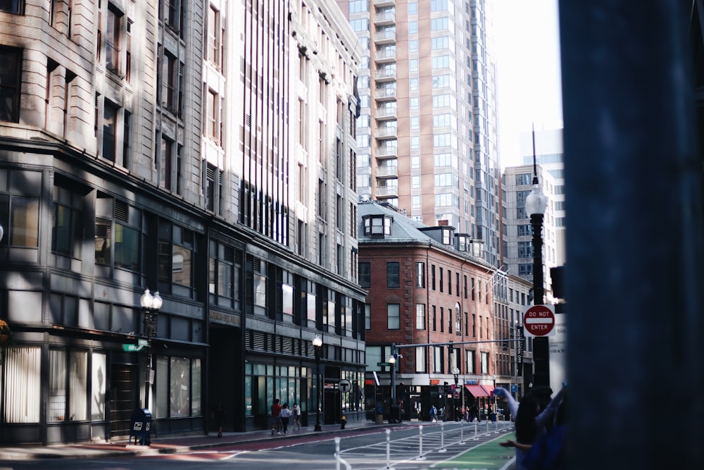 people walking on sidewalk near high rise buildings during daytime