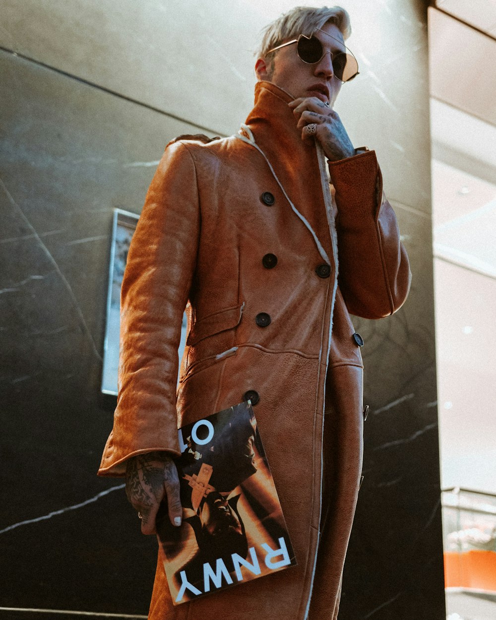 woman in brown coat holding black game controller