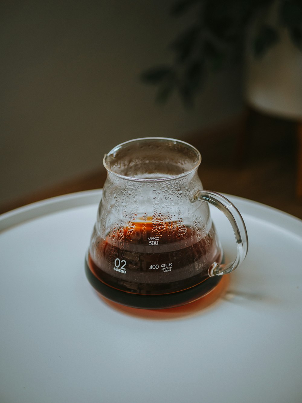 Taza de vidrio transparente en fregadero de cerámica blanca