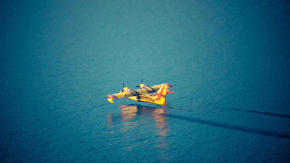 2 Personen fahren tagsüber auf einem gelben Kajak auf blauem Meer