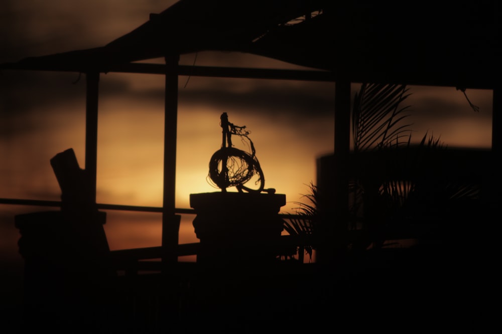 silhouette of a person standing on a gazebo during sunset