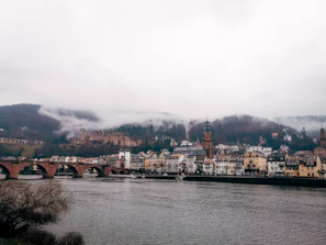 A misty morning view of Loket’s medieval town nestled in a river bend.
