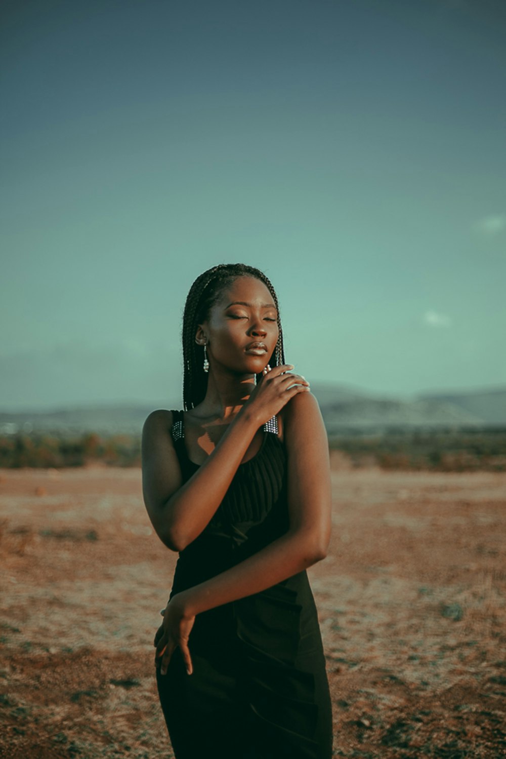 woman in black tank top standing on brown field during daytime