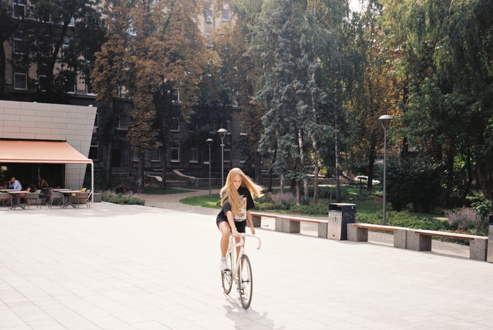 woman in brown coat riding bicycle on road during daytime