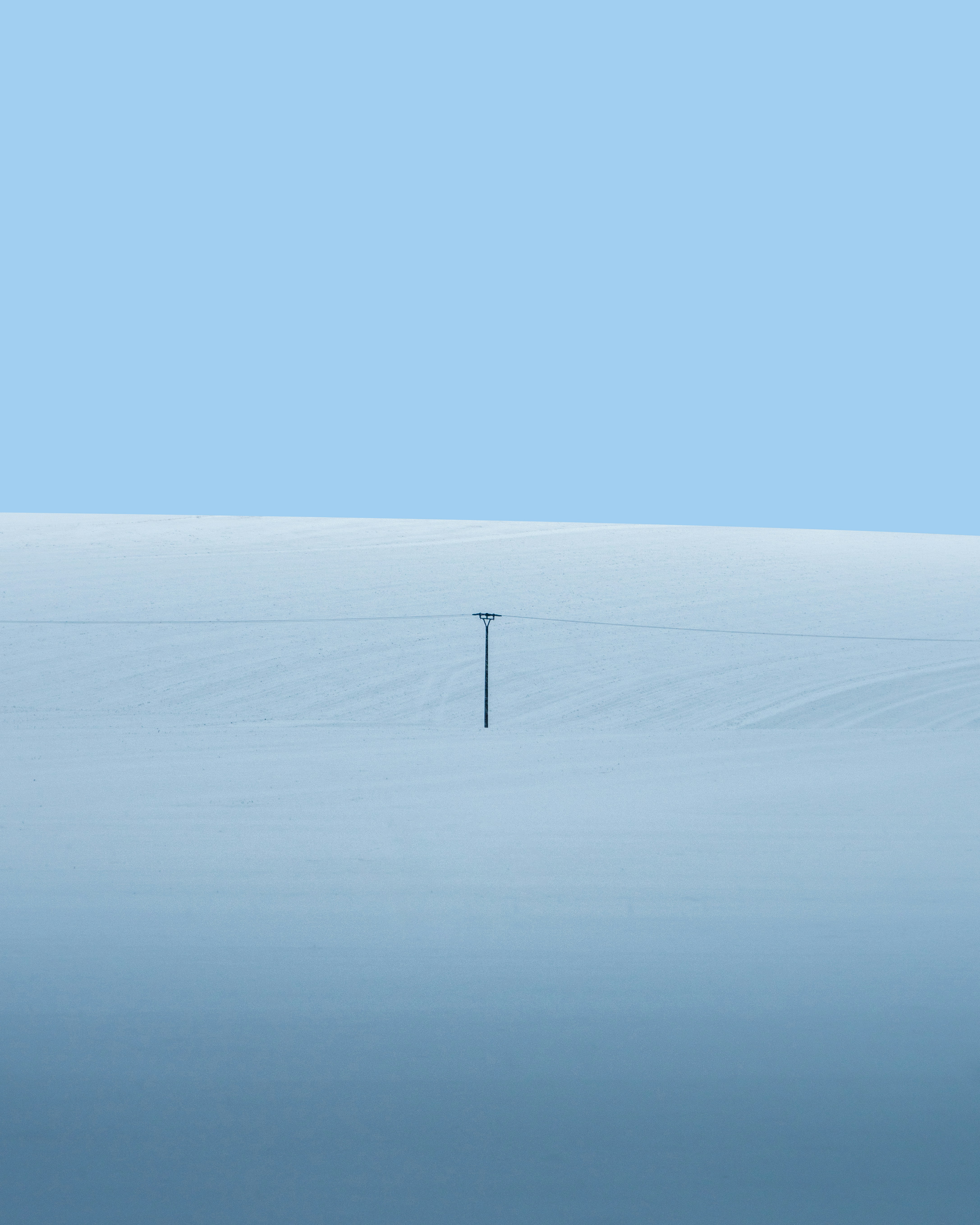 Aerogenerador blanco en campo de nieve blanca