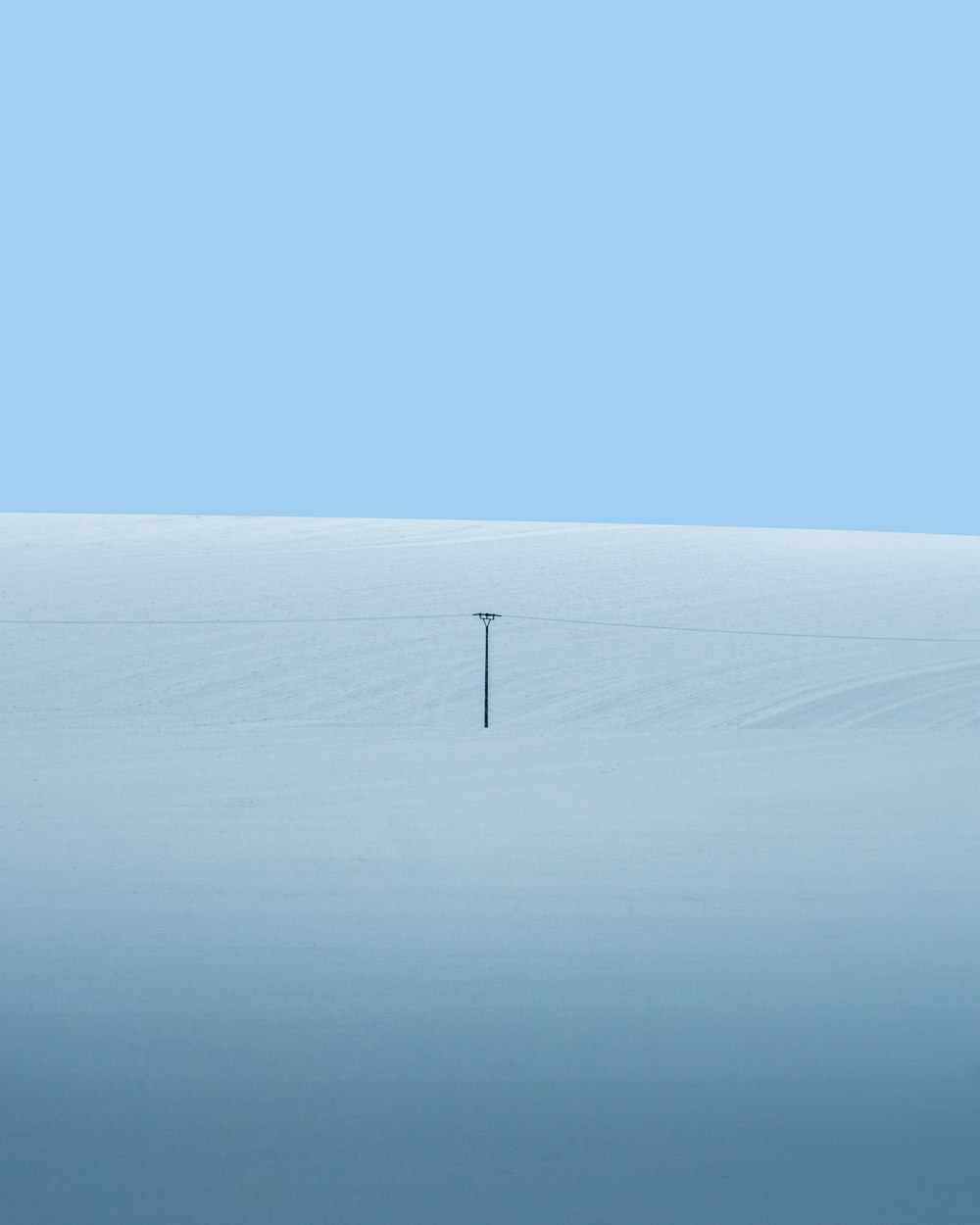 Turbina eolica bianca sul campo di neve bianca