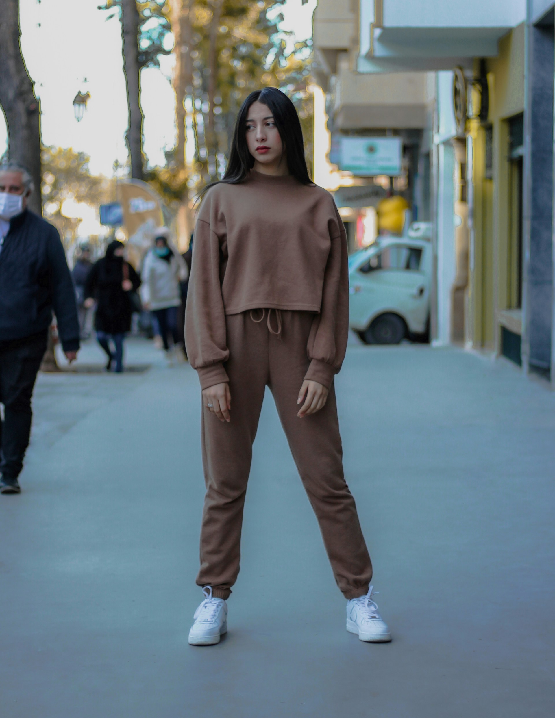 woman in brown long sleeve shirt and brown pants standing on white floor