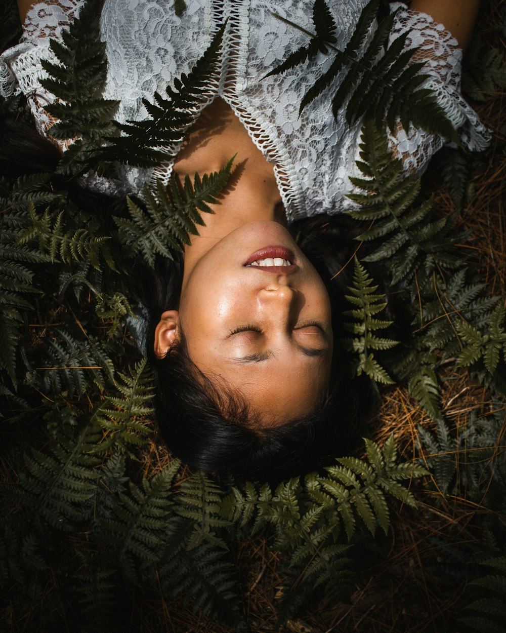 woman lying on green leaves