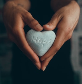 person holding gray heart shape ornament