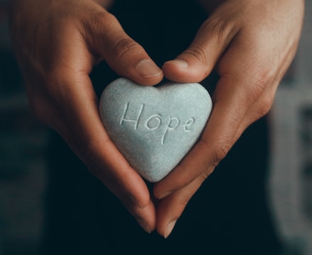 person holding gray heart shape ornament