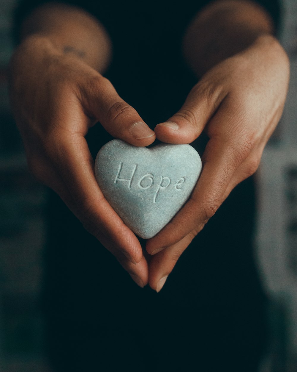 person holding gray heart shape ornament