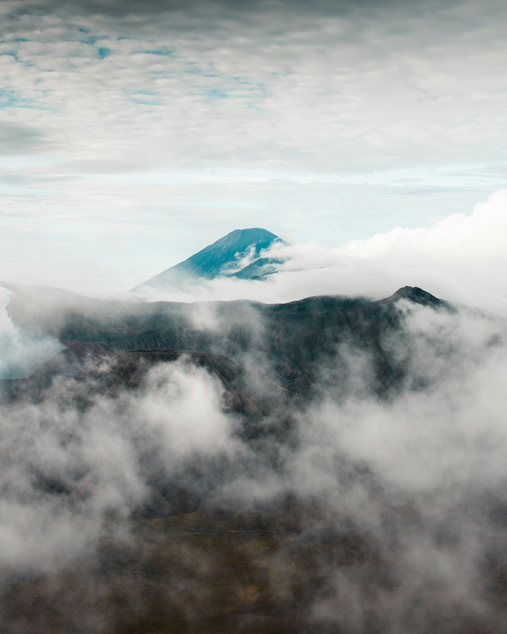 white clouds over snow covered mountain