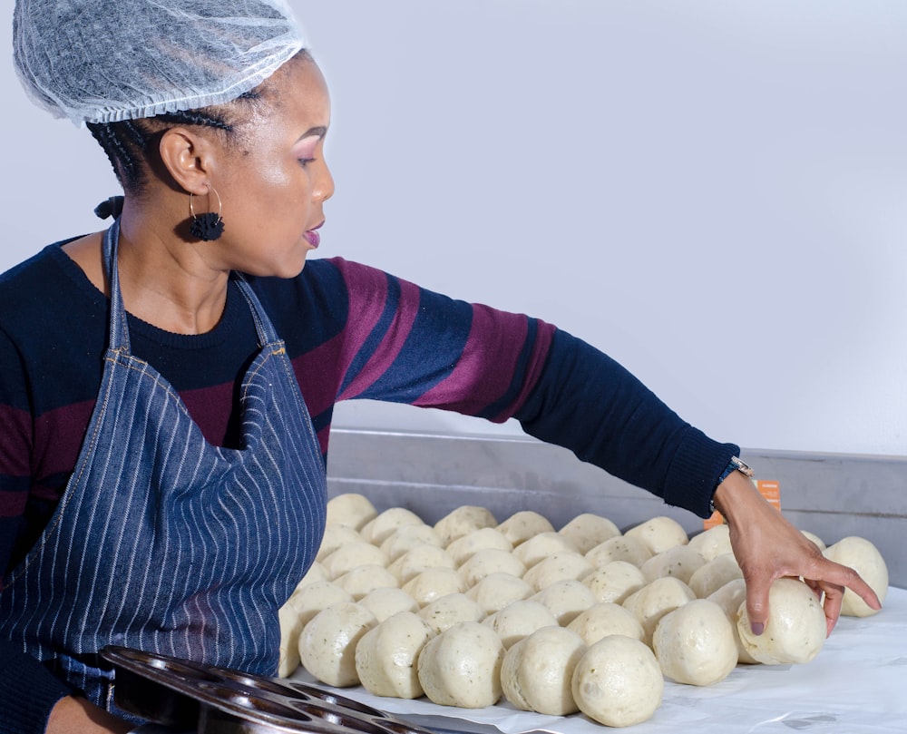 woman in blue and white striped long sleeve shirt holding bread