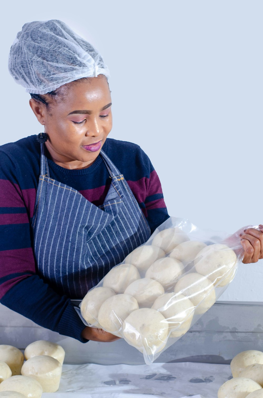 person in blue and red striped long sleeve shirt holding white eggs