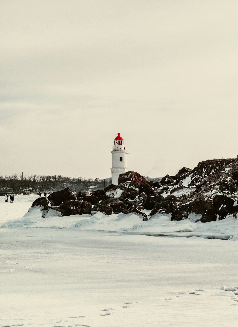 Faro blanco en un terreno cubierto de nieve durante el día