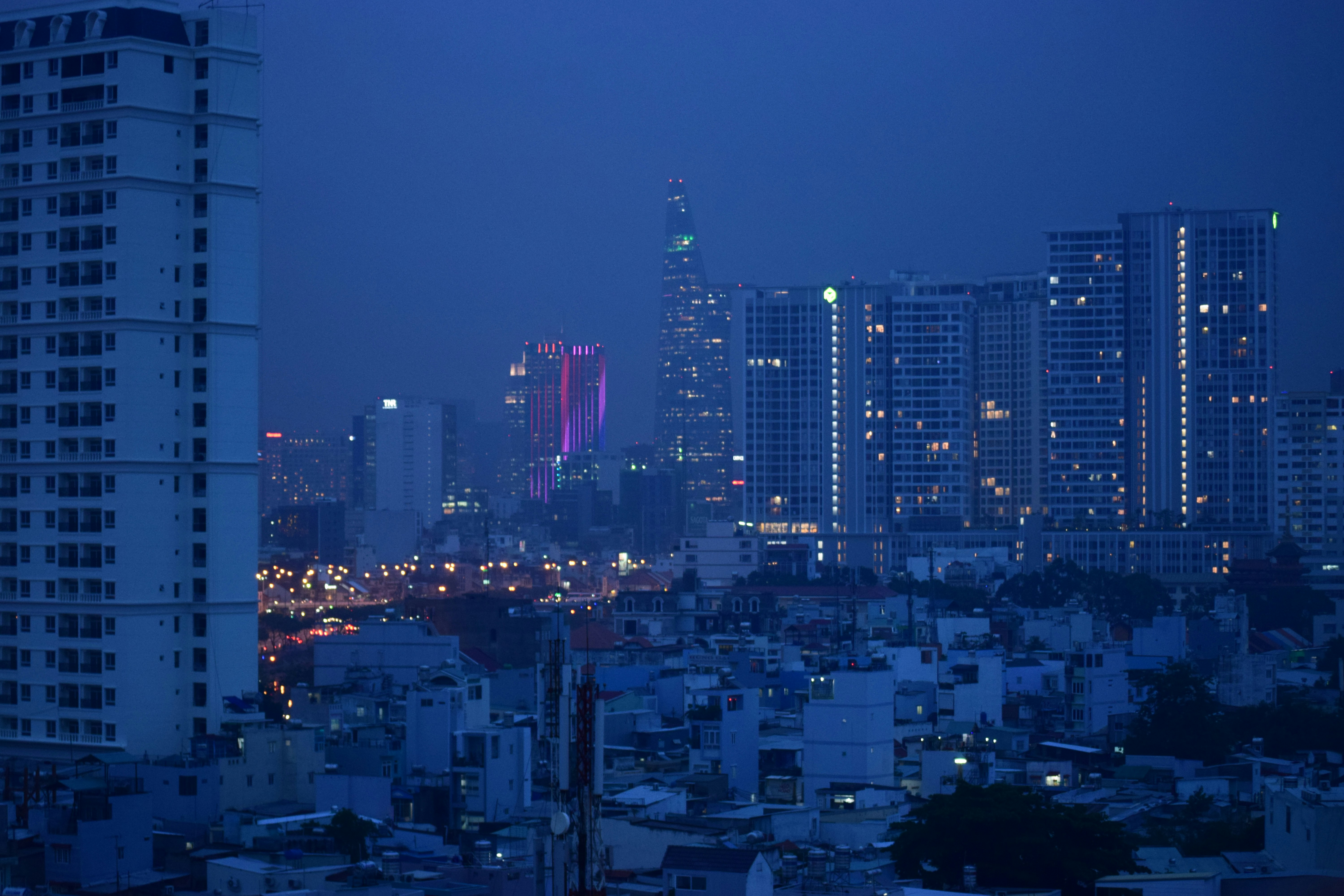 Johannesburg urban skyline night panorama, deep dark sky, city lights glowing amber, dramatic low-key atmosphere