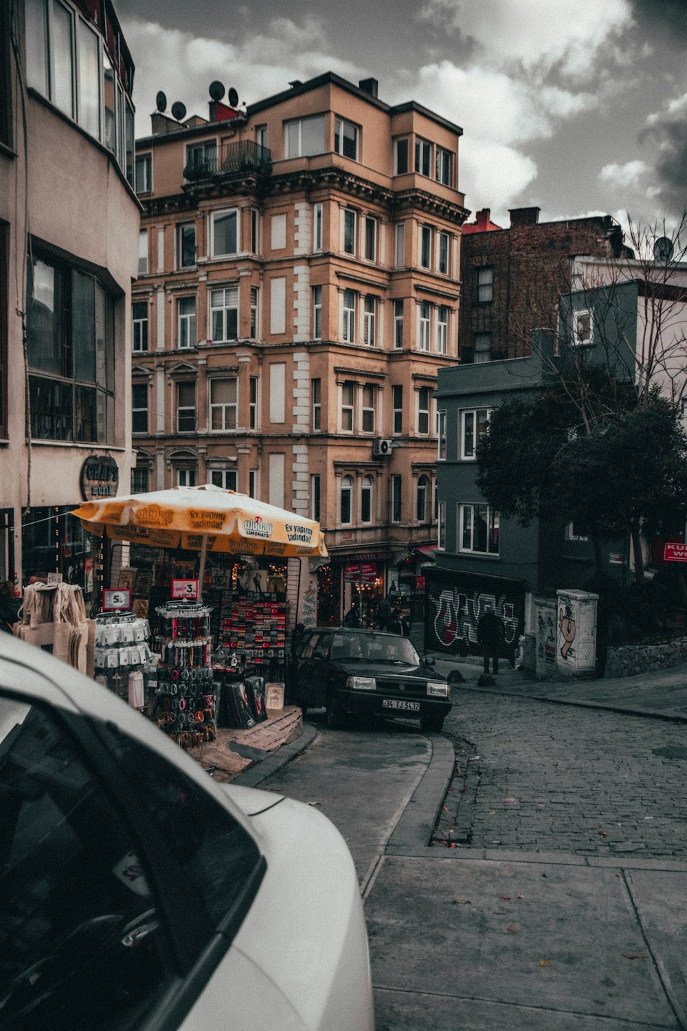 cars parked beside brown concrete building during daytime