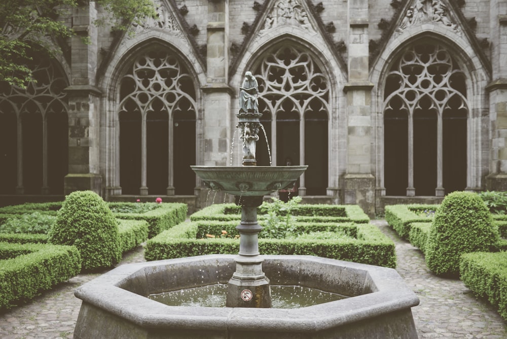 gray concrete fountain in front of white concrete building during daytime