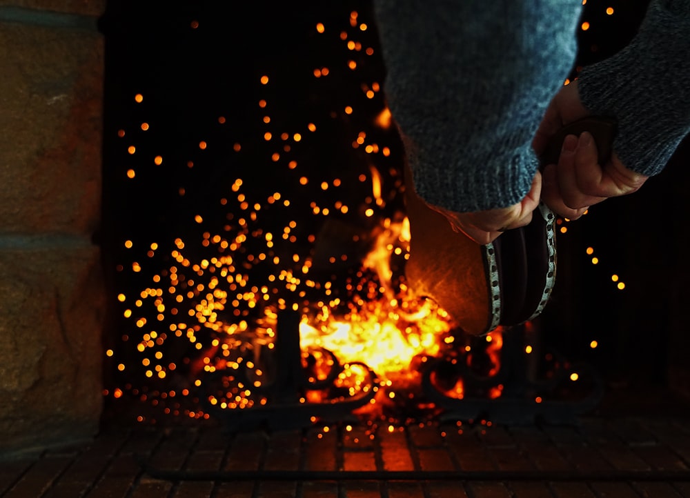 person in blue denim jacket holding fire
