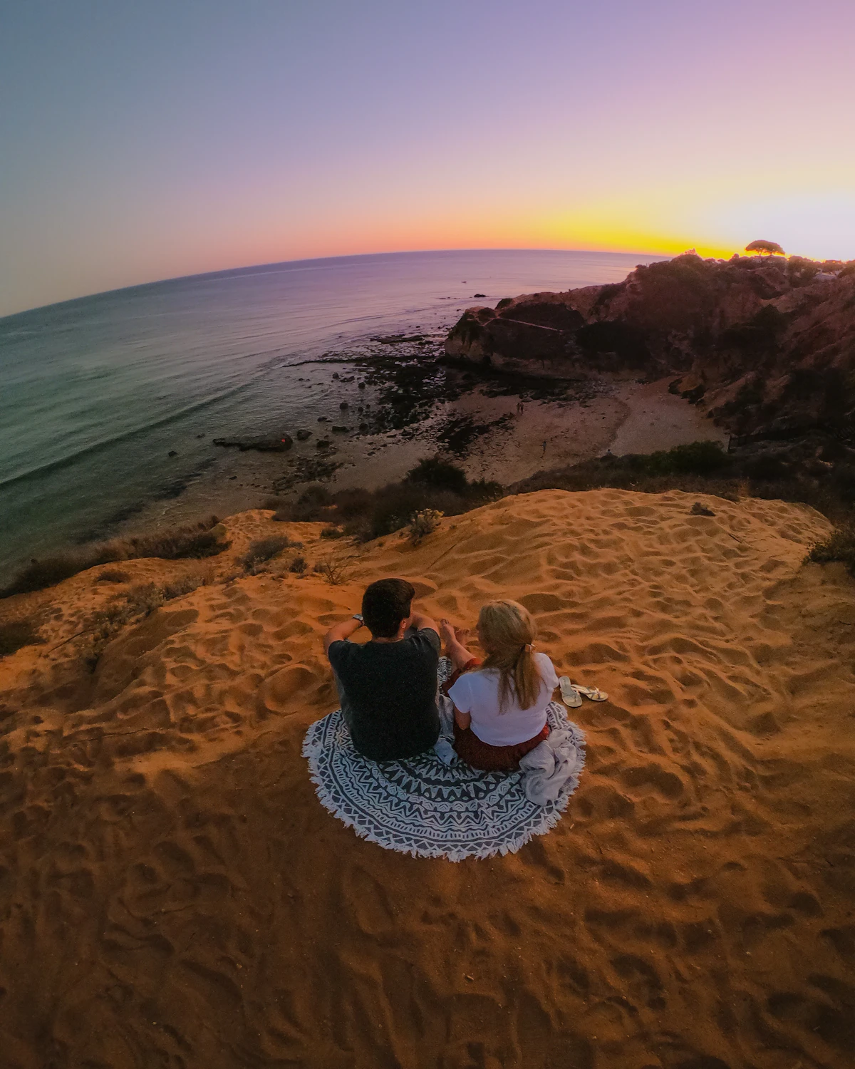 man and woman sitting on brown rock formation during daytime