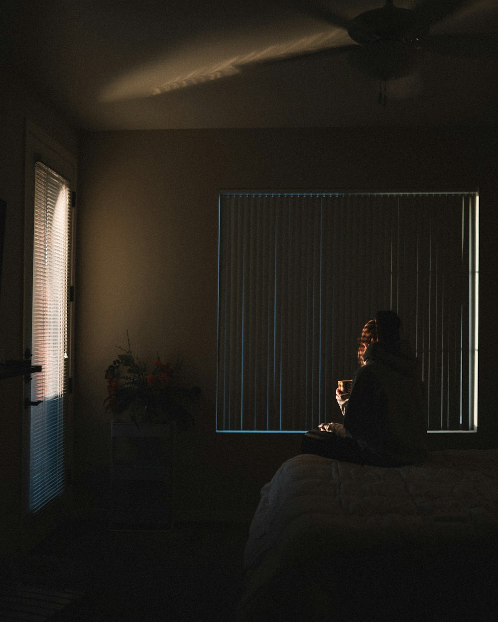 man in black jacket sitting on bed