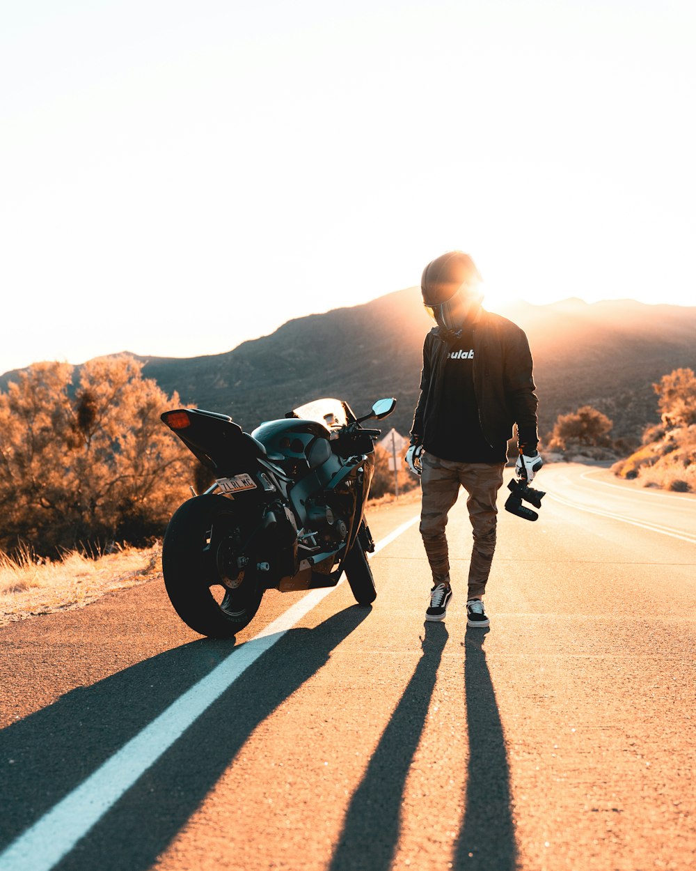 man in black jacket and black pants riding black motorcycle on road during daytime