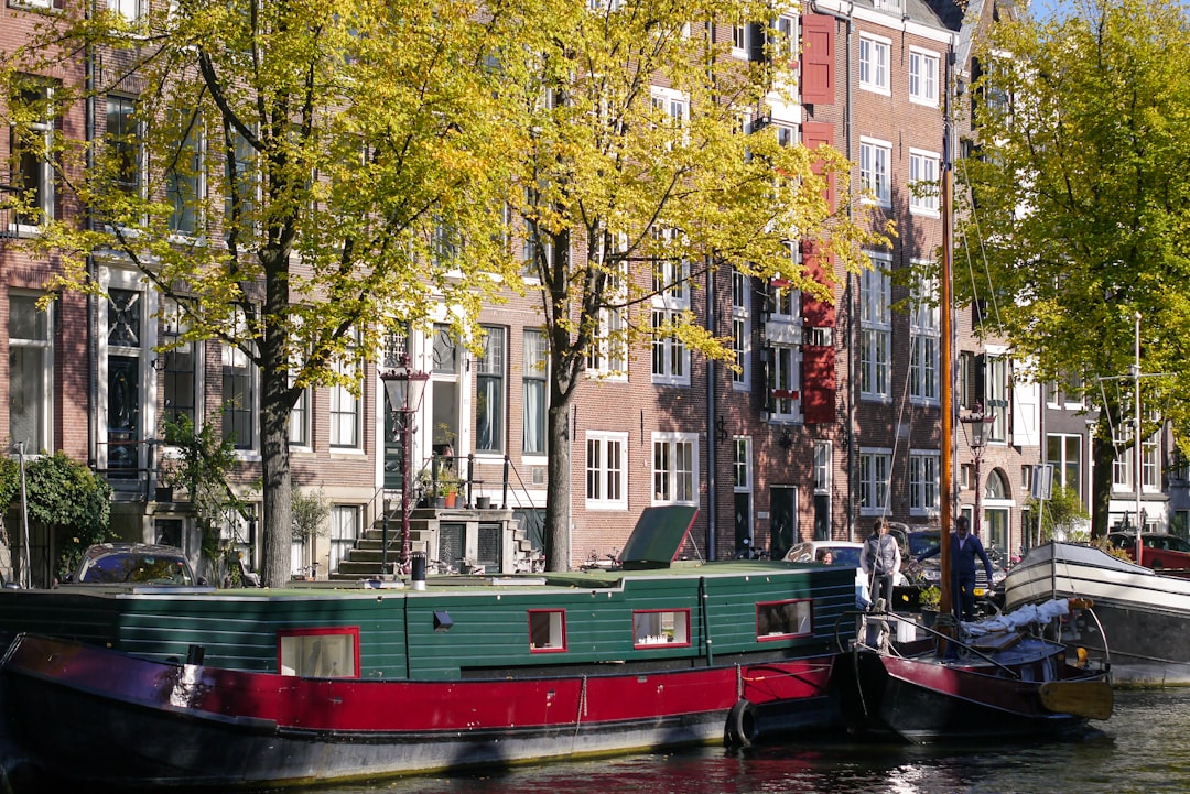 boat on river near trees and buildings during daytime