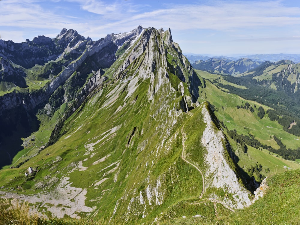 green and gray mountain under white clouds during daytime