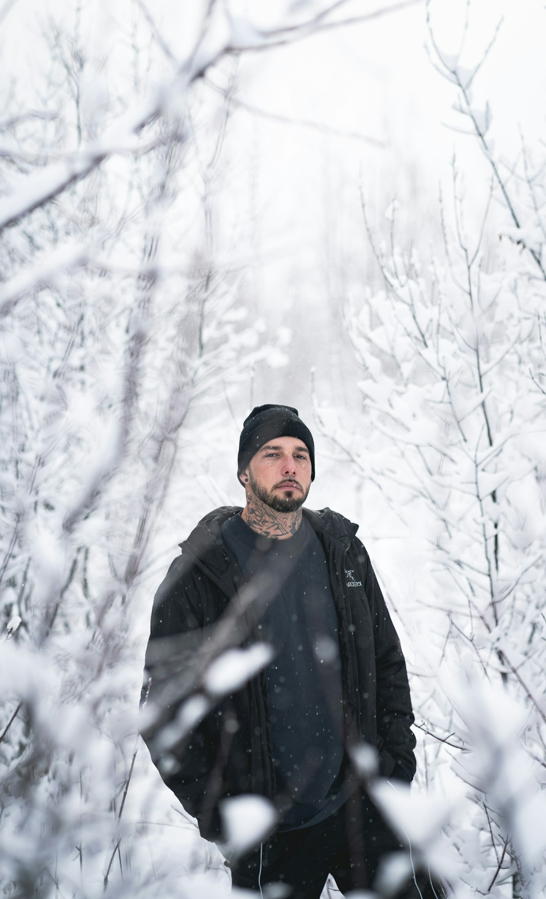 man in black jacket standing on snow covered ground during daytime