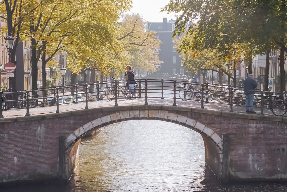 people walking on bridge over river during daytime