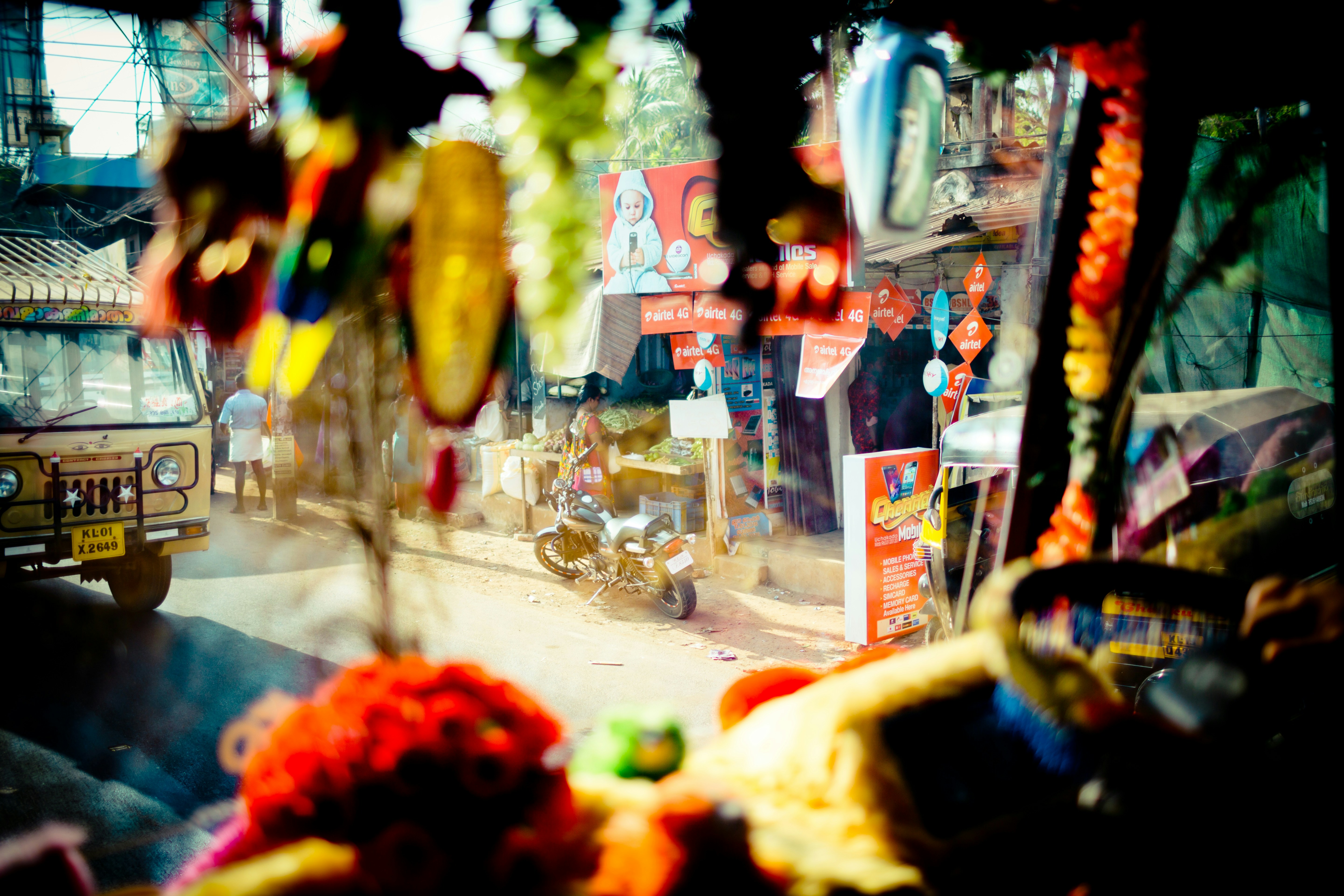 A busy Indian market street scene, with various food vendors and small shops bustling with customers. Focus on the variety of businesses that will be impacted.