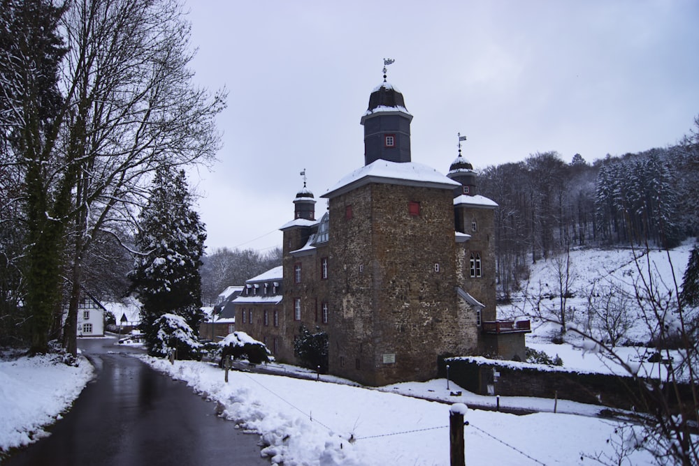 brown concrete building surrounded by snow covered ground