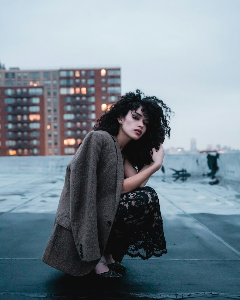 woman in black and white floral dress sitting on concrete floor