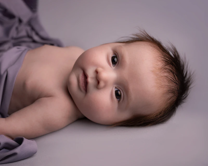 Baby lying peacefully on a white bed